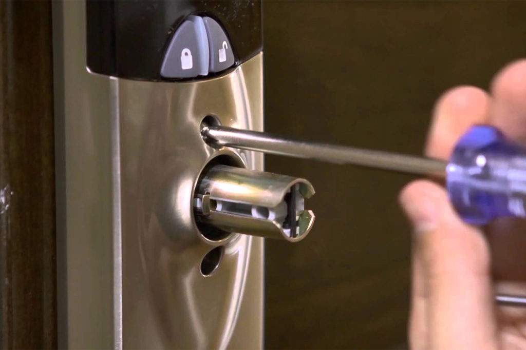 Commercial locksmith servicing a business door lock in Frisco TX